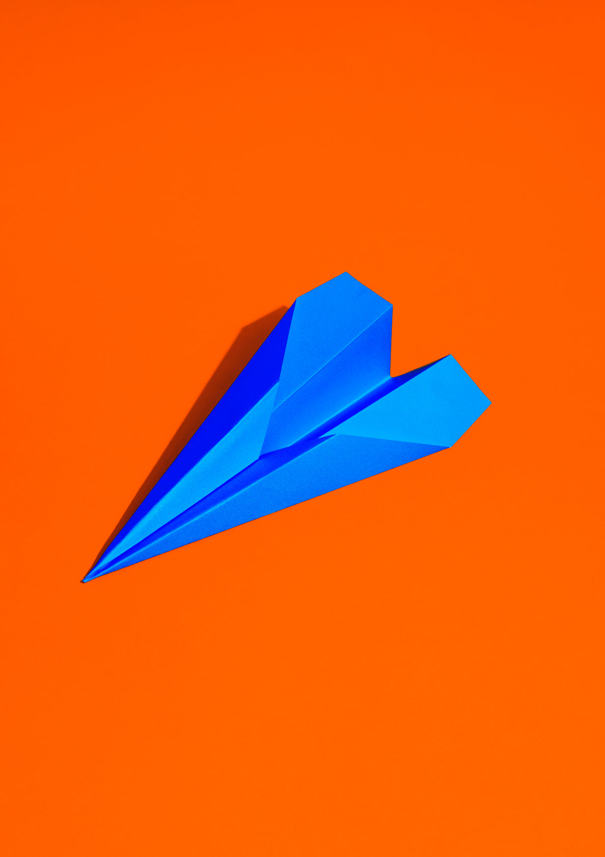 Royal blue paper plane on a red background / Pop art style photo print