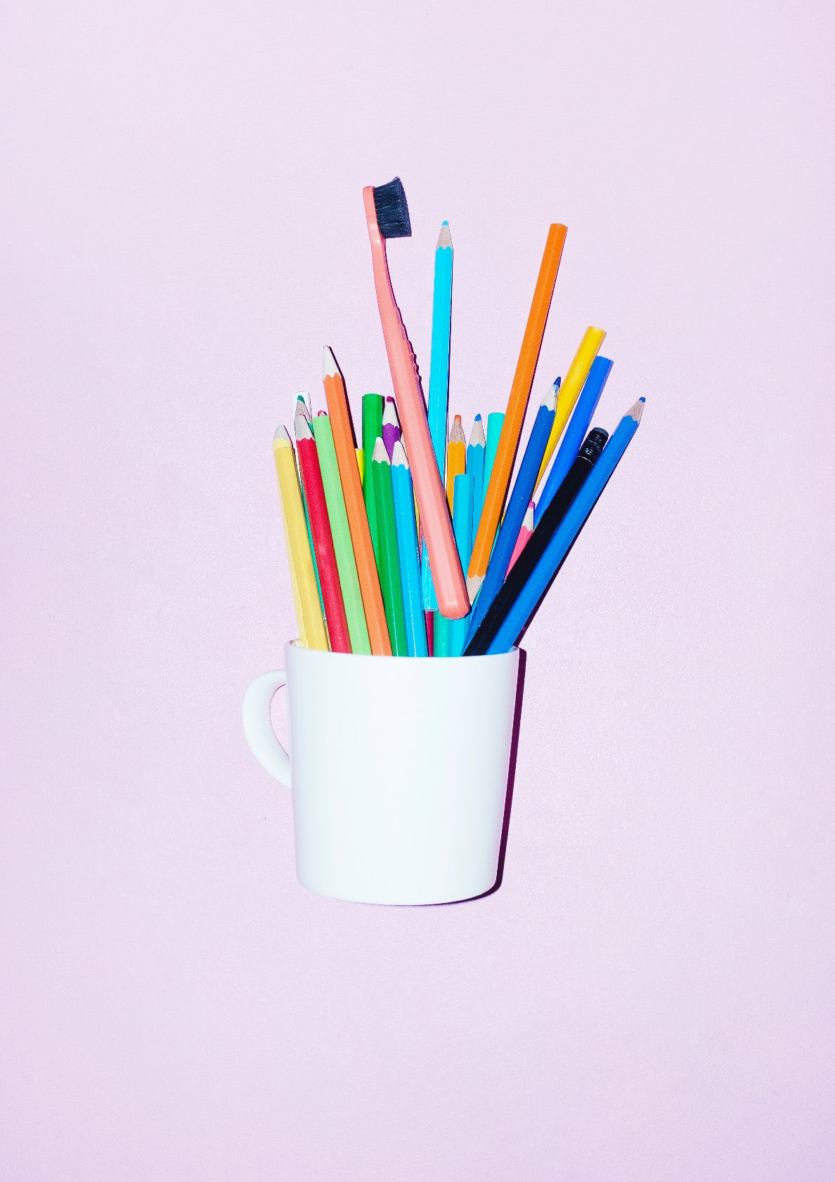 Coffee cup with colourful pencils