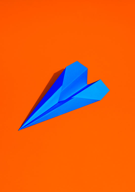Royal blue paper plane on a red background / Pop art style photo print