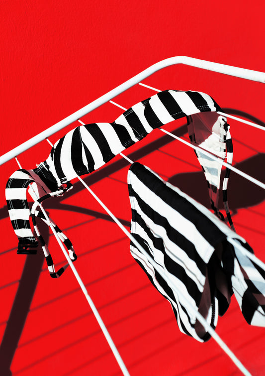 Black-and-white stripe pattern bikini oon a front of red wall / Pop art style photo print
